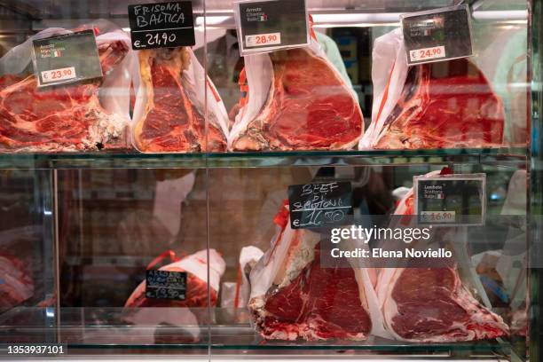 fresh steak meat in a butcher store window - butcher foto e immagini stock