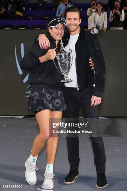 Garbiñe Muguruza of Spain holds Billie Jean King trophy and poses for a picture with Arthur Borges during Day 8 of 2021 Akron WTA Finals Guadalajara...