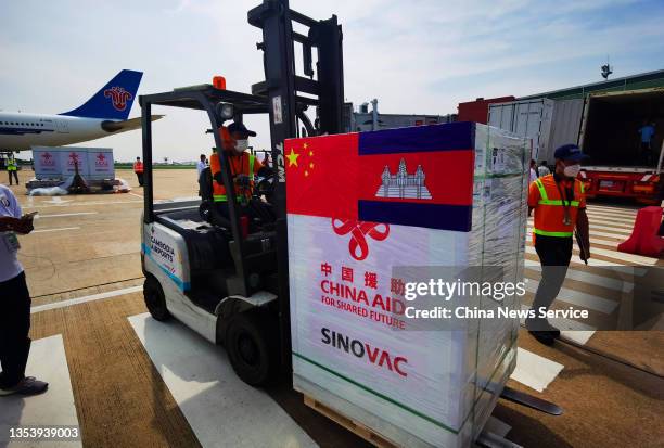 Workers unload boxes of COVID-19 vaccines from an Airbus A330-300 aircraft of China Southern Airlines during the handover ceremony of the 7th batch...