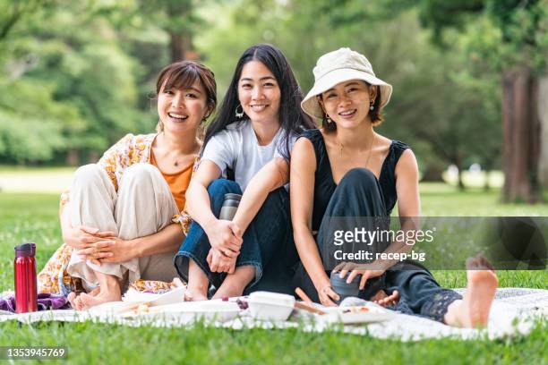 自然の中でピクニックを楽しみながら3人の女性の友人の肖像画 - 友達 ストックフォトと画像
