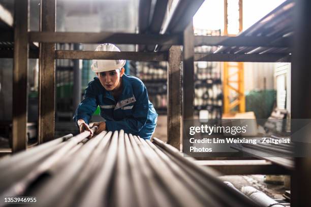 stahlfabrikarbeiterin bei der arbeit - metal industry stock-fotos und bilder