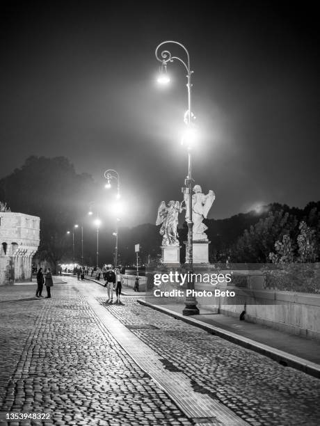 a suggestive noir atmosphere along the banks of the tiber river in the historic heart of rome - noir stock pictures, royalty-free photos & images