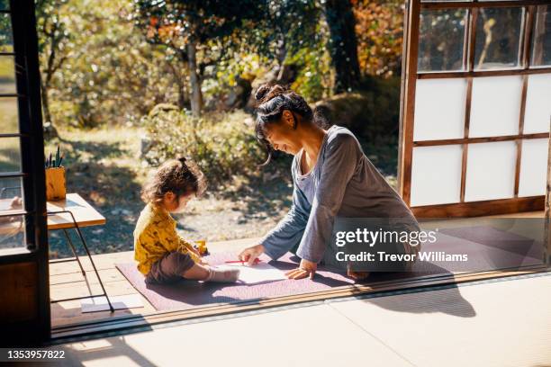 pregnant mother trying to keep her children entertained so she can finish her yoga - grand prix of japan practice stockfoto's en -beelden