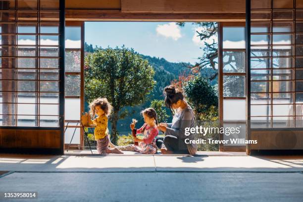 pregnant mother making braids in her daughters hair - japanese stock pictures, royalty-free photos & images