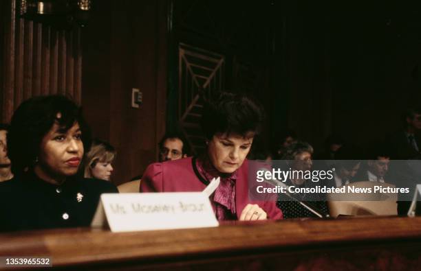 American politician and diplomat Carol Moseley Braun, wearing a black outfit, and American politician Dianne Feinstein, wearing a pink outfit, during...