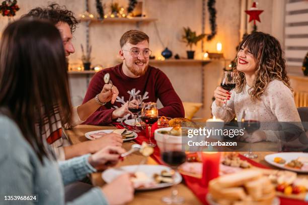 friends having christmas dinner together - christmas europe stock pictures, royalty-free photos & images