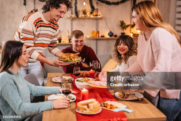 paar serviert weihnachtsessen für freunde - table dinner winter stock-fotos und bilder