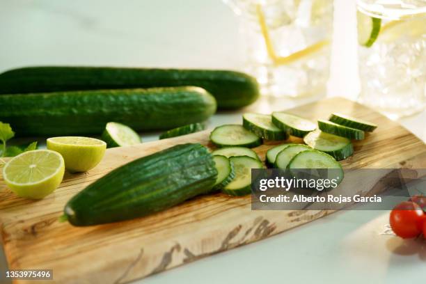 cucumber and lime on wooden cutting board for refreshing drink - cucumber imagens e fotografias de stock