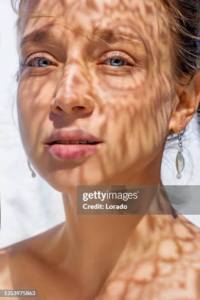 headshot di un volto femminile dietro l'ombra estiva - raggiante foto e immagini stock