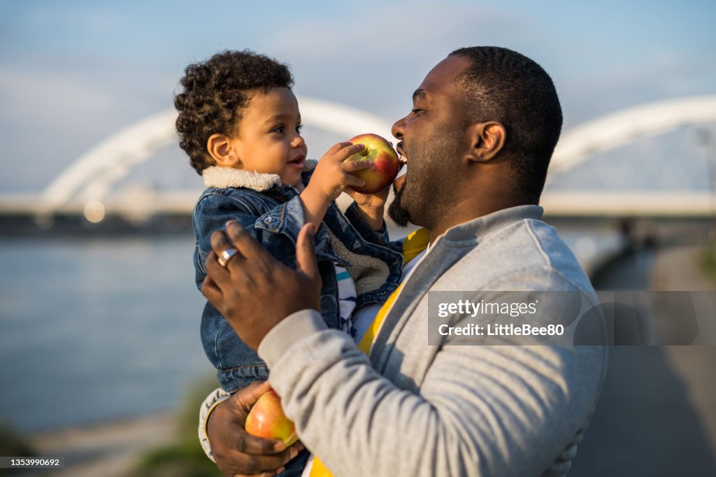 Father and son eating apples