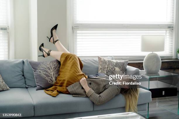 a middle-aged woman lying on the sofa - women lying stock-fotos und bilder