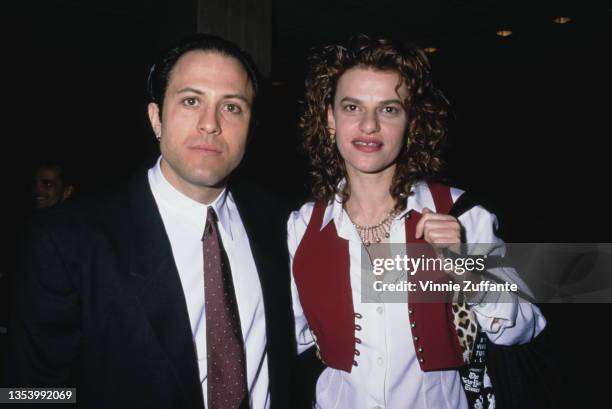 American fashion designer Isaac Mizrahi, wearing a black suit with a white shirt and burgundy tie, and American actress and comedian Sandra Bernhard,...