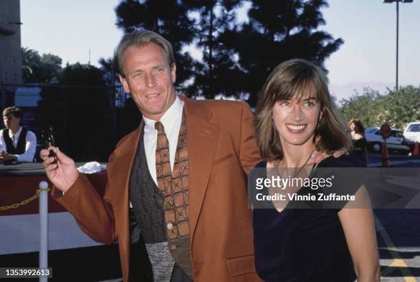 American actor Corbin Bernsen, wearing a tan jacket with a patchwork waistcoat, and his wife, British actress Amanda Pays, wearing a black sleeveless...