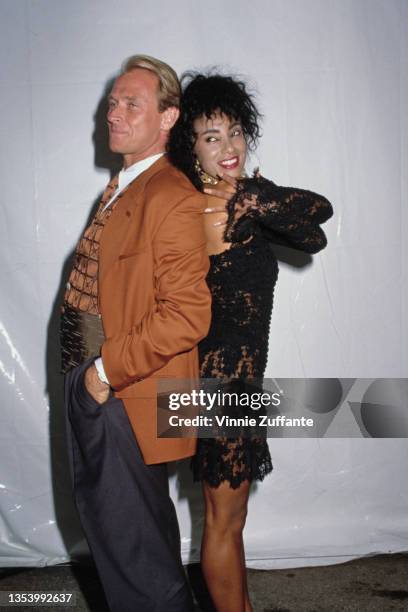 American actor Corbin Bernsen, wearing a tan jacket with a patchwork waistcoat, and British MTV presenter and actress Downtown Julie Brown, wearing a...