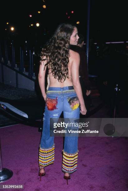 American actress Elizabeth Berkley, wearing a gold fringed top with jeans, with multi-coloured hems, attends the party celebrating the launch of...