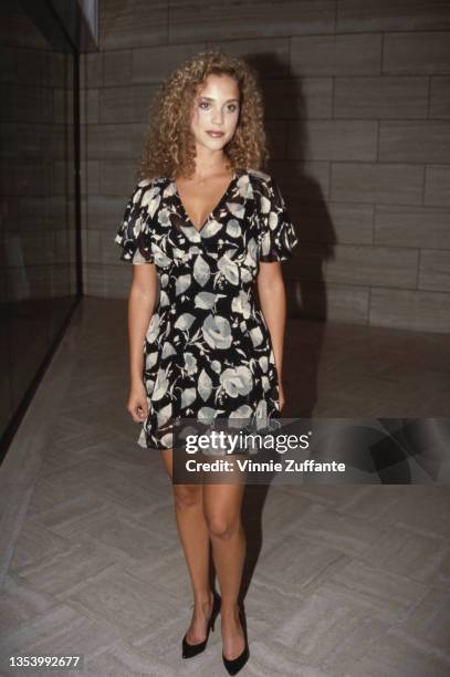 American actress Elizabeth Berkley, wearing a black-and-white floral pattern minidress, United States, circa 1995.