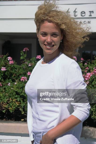 American actress Elizabeth Berkley, wearing a white t-shirt beneath a white cardigan, at the Shutters on the Beach hotel on the beachfront in Santa...