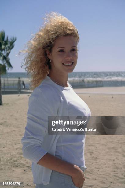 American actress Elizabeth Berkley, wearing a white t-shirt beneath a white cardigan, at the Shutters on the Beach hotel on the beachfront in Santa...