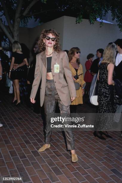American actress and comedian Sandra Bernhard, wearing a tan blazer with a black tube top and sunglasses, attends the 1989 MTV Video Music Awards,...