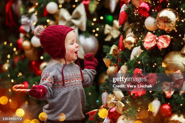 child at christmas tree on xmas eve. it is miracle. family with kids celebrating christmas . boy cute child cheerful mood play near christmas tree. - marché de noël photos et images de collection