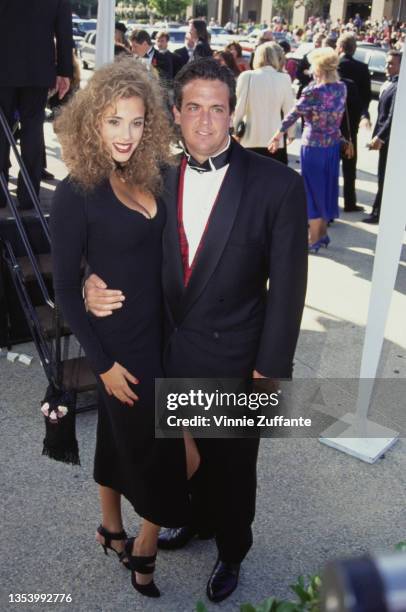 American actress Elizabeth Berkley, wearing a black choker neck cut-out dress, and American talent manager and television producer Brian Medavoy, in...