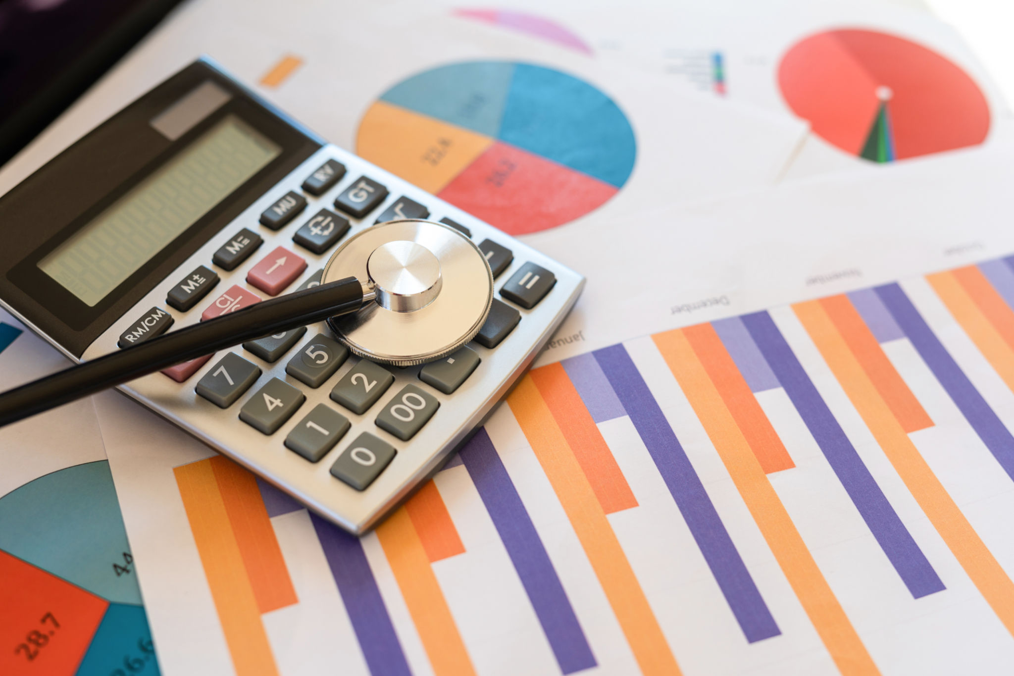 Financial statement with stethoscope and calculator Financial statement with stethoscope and calculator