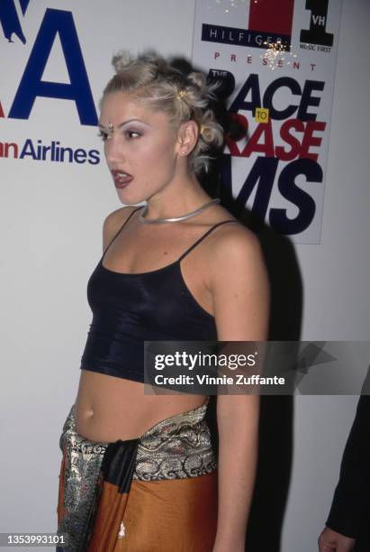 American singer Gwen Stefani, wearing a black crop top with an orange-and-silver wrap skirt, attends the 5th Annual Race to Erase MS Gala, held at...
