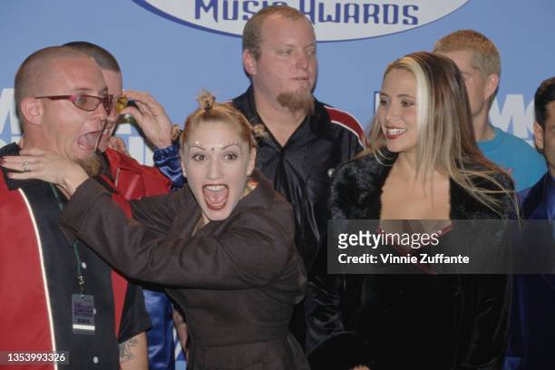 American singer Gwen Stefani with members of American ska punk band Sublime and a woman, in the press room of the 1997 Billboard Music Awards, held...