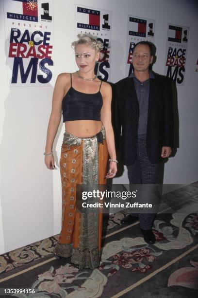 American singer Gwen Stefani, wearing a black crop top with an orange-and-silver wrap skirt, attends the 5th Annual Race to Erase MS Gala, held at...