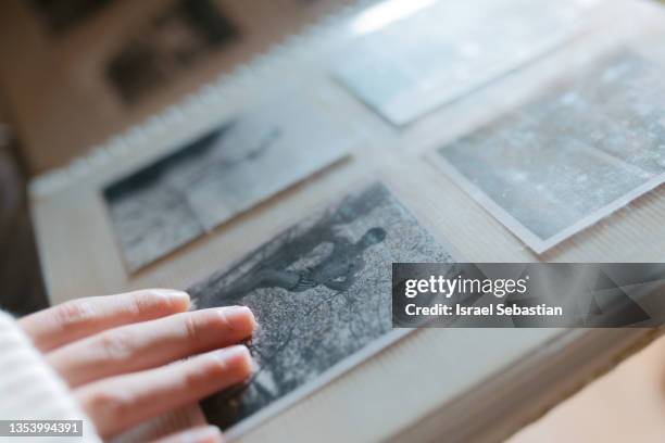 close up view of a person watching an old family photo album. - vintage photograph stock pictures, royalty-free photos & images