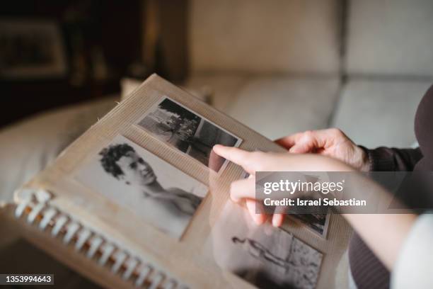 loving grandmother watching the old family photo album with her granddaughter at home. - old photos stock pictures, royalty-free photos & images