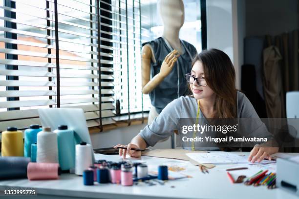 young asian fashion designer working in her home studio. - atelier fashion stock pictures, royalty-free photos & images