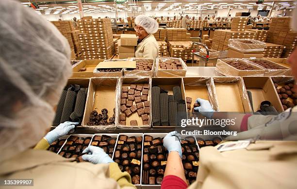 Belt stockers pack boxes of chocolates at the See's Candies Inc. Packing facility in South San Francisco, California, U.S., on Thursday, Dec. 8,...