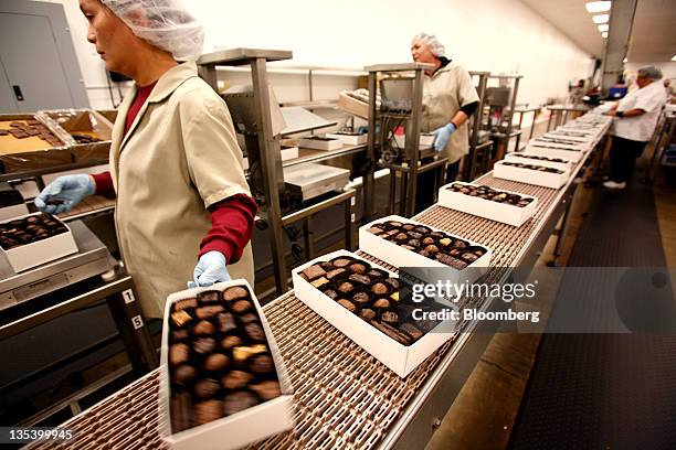 Scalers weigh boxes of assorted chocolates on the production line at the See's Candies Inc. Packing facility in South San Francisco, California,...