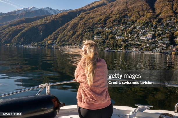 young woman on boat enjoys the lake in autumn - ascona 個照片及圖片檔