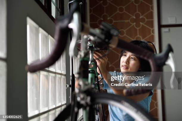 woman fixing her bike in an apartment - diy beauty stock pictures, royalty-free photos & images