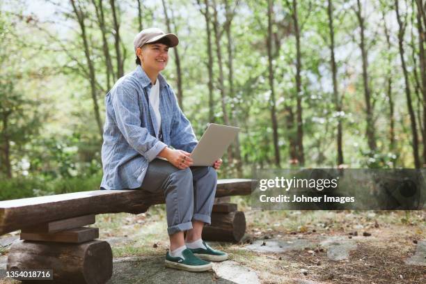 young woman with laptop sitting on bench - androgynous stock pictures, royalty-free photos & images