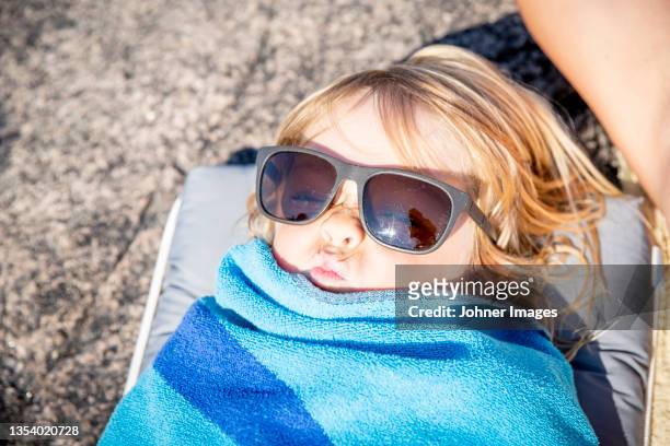 child in sunglasses wrapped in beach towel - johner images bildbanksfoton och bilder