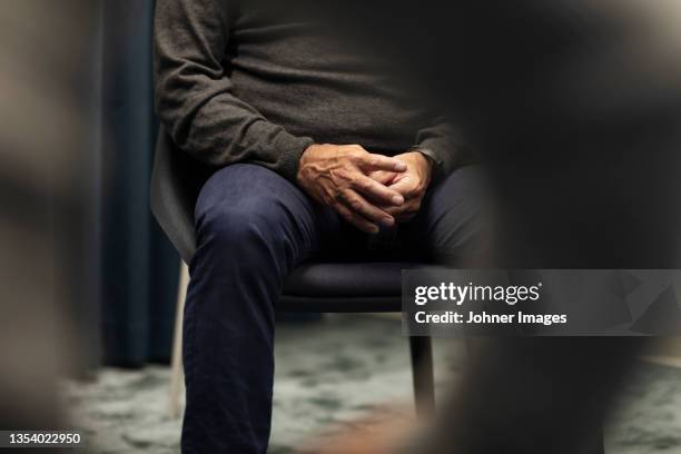 mid section of man sitting during meeting - psicología fotografías e imágenes de stock