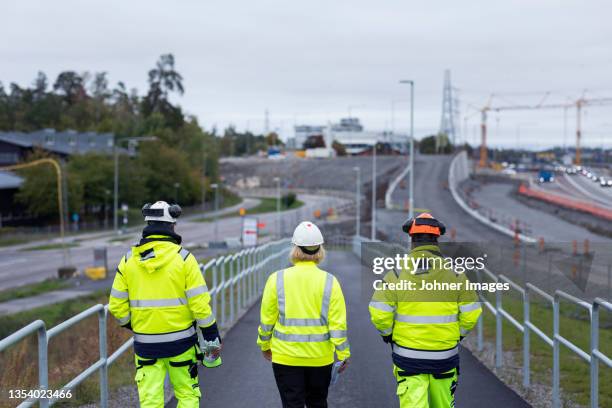 construction workers walking along road - road works stockfoto's en -beelden