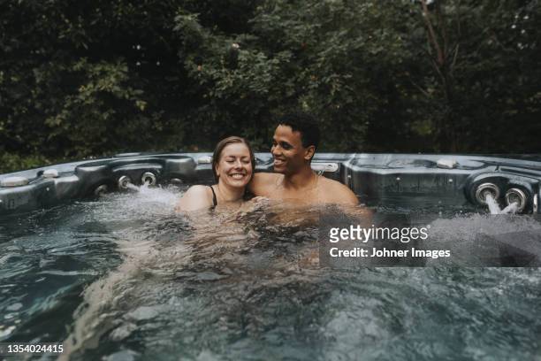 couple relaxing in hot tub - hot tub stock pictures, royalty-free photos & images