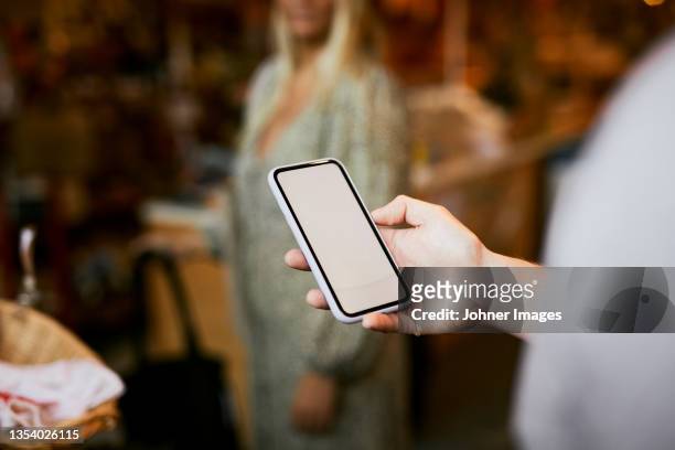 man using phone in shop - johner images bildbanksfoton och bilder