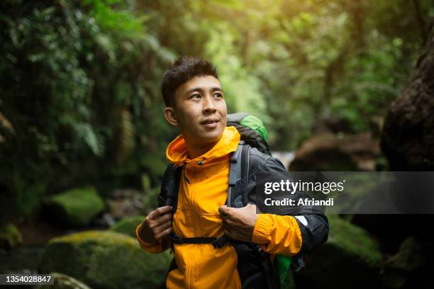 young man in tropical mountain forest - male backpacker stock pictures, royalty-free photos & images