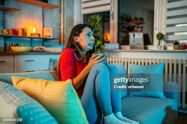 woman got scared while watching movie at home - woman watching horror movie stock pictures, royalty-free photos & images