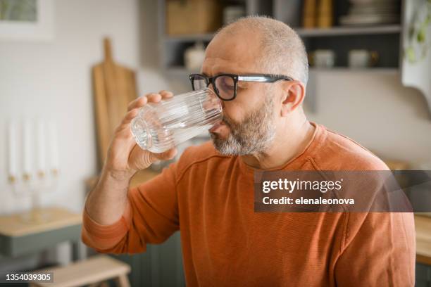 homme adulte mature buvant de l’eau - man drinking water photos et images de collection