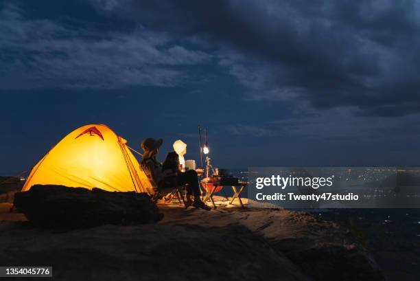 couple enjoys the camping in vacation looking at the stars at night on mountain - camping stove stockfoto's en -beelden