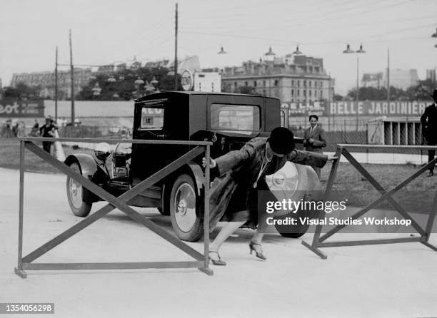 French dancer and actress Marcelle Rahna moves a road barrier as after entering the grounds at the Velodrome de Parc des Princes, Paris, France,...