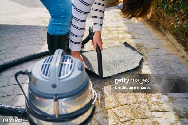 closeup shot of a young female driver cleaning carpets with a vacuum cleaner - rug isolated stock pictures, royalty-free photos & images