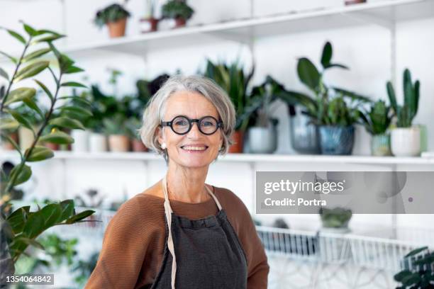 retrato de florista senior en su tienda - mujer mayor fotografías e imágenes de stock