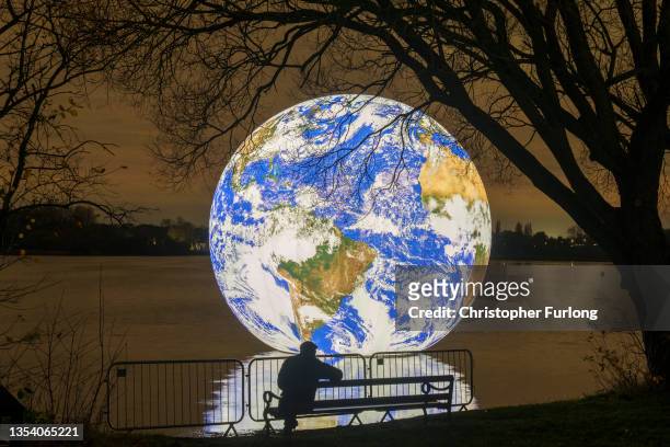 People view artist Luke Jerram's new 'Floating Earth' Debuts In Wigan on November 18, 2021 in Wigan, England. The floating Earth will hover over...